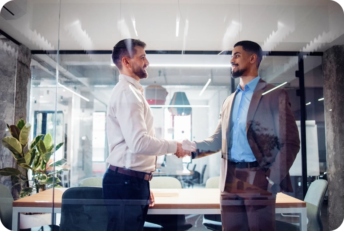 Businessmen shaking hands in office